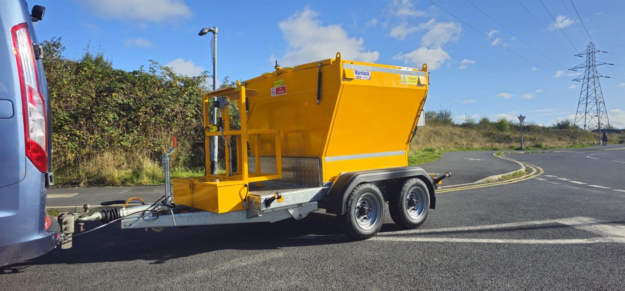 Towable Hotbox with a burner control frame, hitched to a van on a local road
